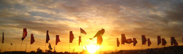 flags at sunset at Glastonbury music festival